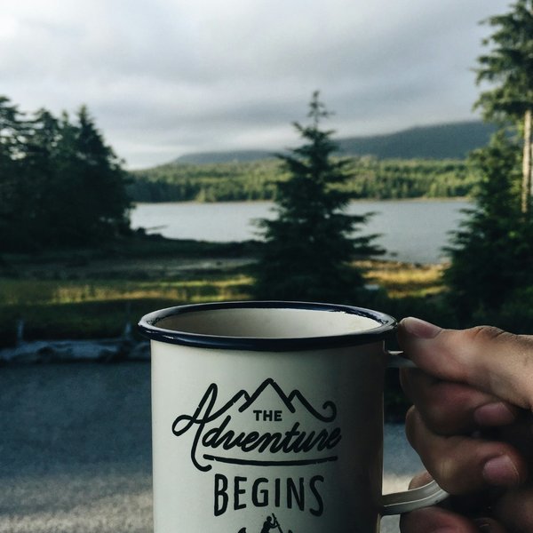 A cup with "adventure begins" written on it