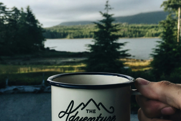 A cup with "adventure begins" written on it