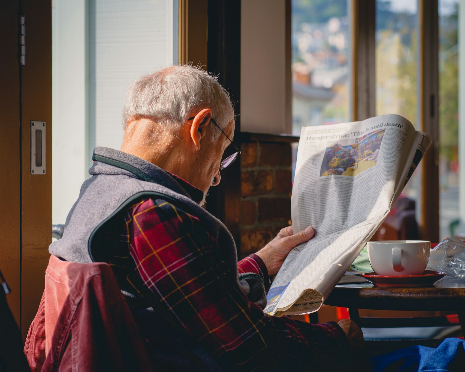 Man in cafe reading newspaper